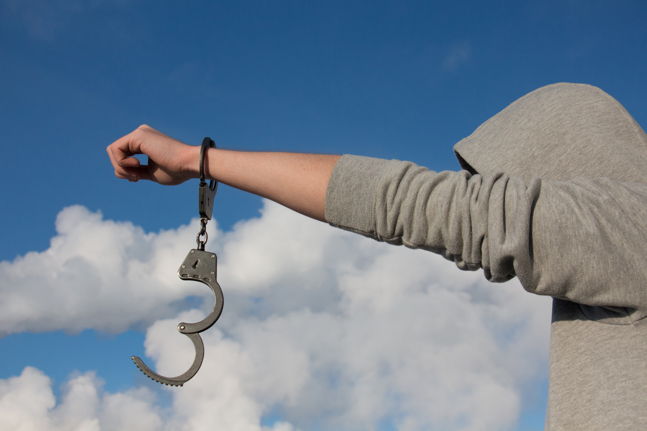 Man in handcuffs on Sky Background